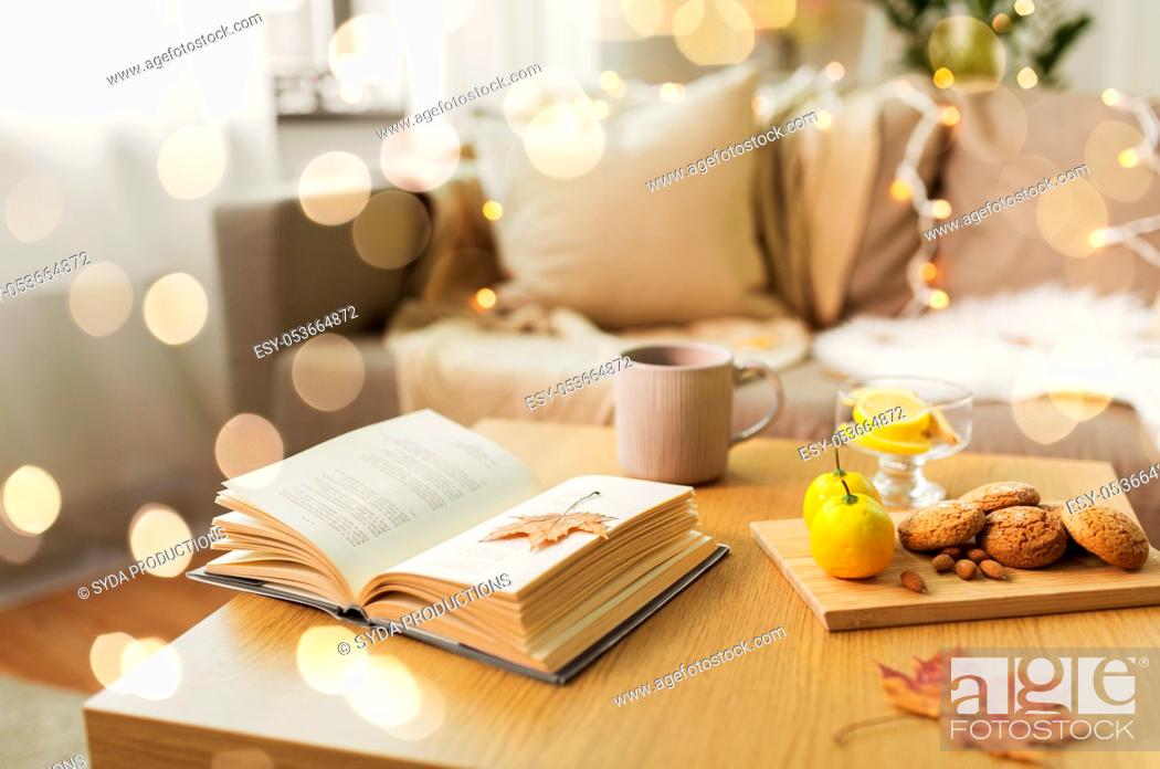 Stock Photo: book, lemon, tea and cookies on table at home.