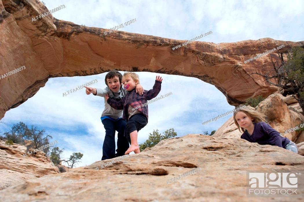Stock Photo: Children exploring near Owachomo Bridge, Natural Bridges National Monument, Utah, USA.