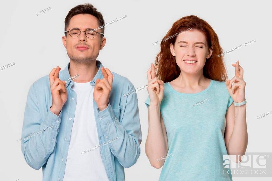 Photo de stock: Superstitious young couple crossing fingers wish for good luck concept, funny stressed man and woman begging for help hoping for win believe in superstition.