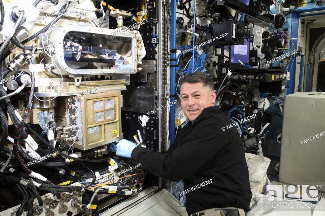 Stock Photo: NASA astronaut and Expedition 65 Flight Engineer Shane Kimbrough installs and configures a new Advanced Colloids Experiment module inside the U.S.