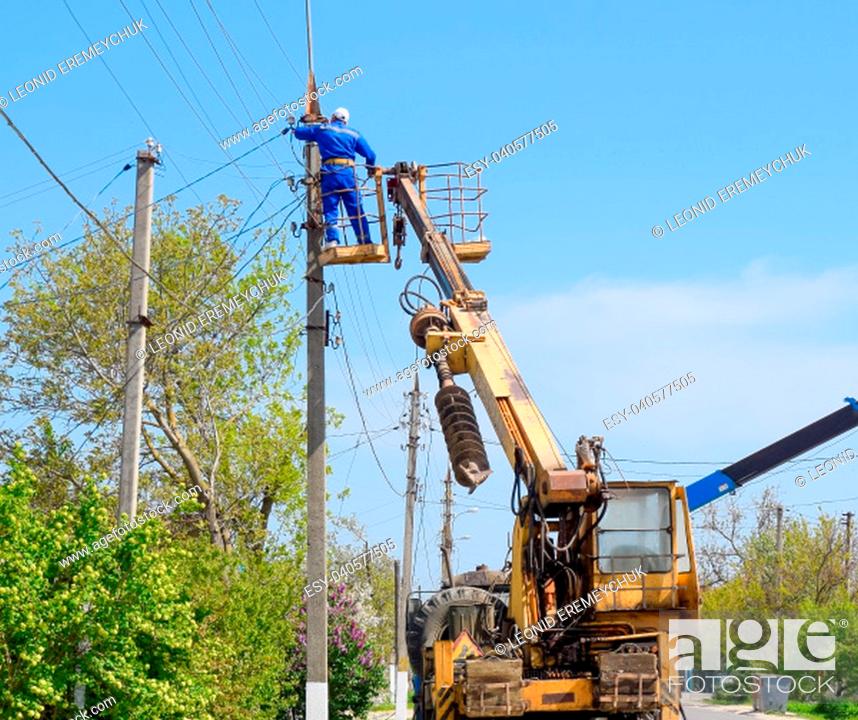 Stock Photo: Slavyansk-on-Kuban, Russia - 24 April, 2018: Electricians repair the power line. Workers are locksmith electricians.