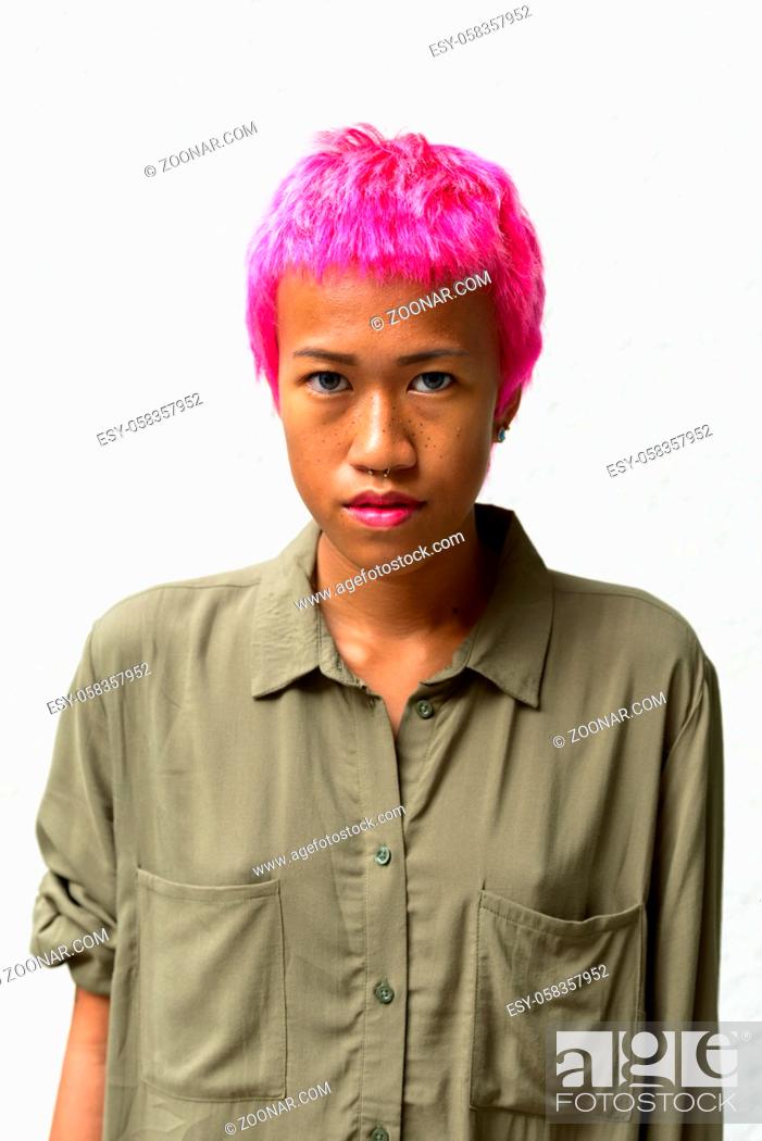 Stock Photo: Portrait of young rebellious Asian woman with pink hair against white background.