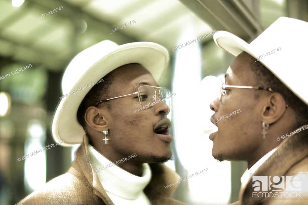 Stock Photo: man breathing on mirror, looking at himself, self-perception, wearing Christian cross earring, in Munich, Germany.