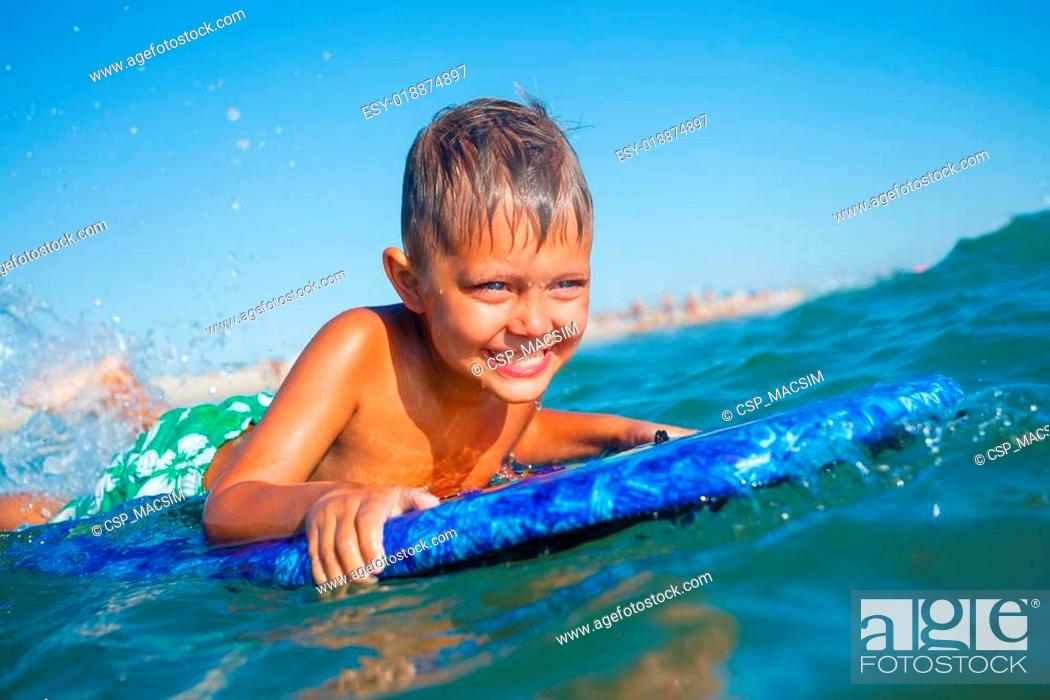 Stock Photo: boy has fun with the surfboard.