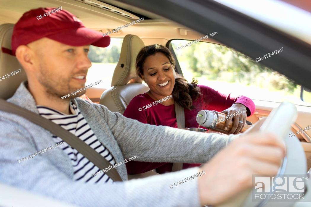 Stock Photo: Couple drinking coffee in car on road trip.