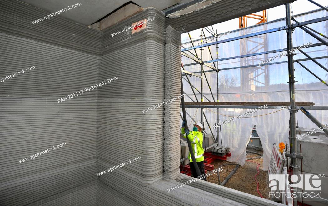 Photo de stock: 17 November 2020, Bavaria, Weißenhorn: Concrete is transported through a hose to the first floor of a building shell. The house.