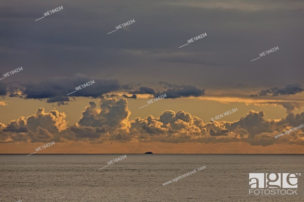 Stock Photo: Cloudy dawn with ship on horizon.