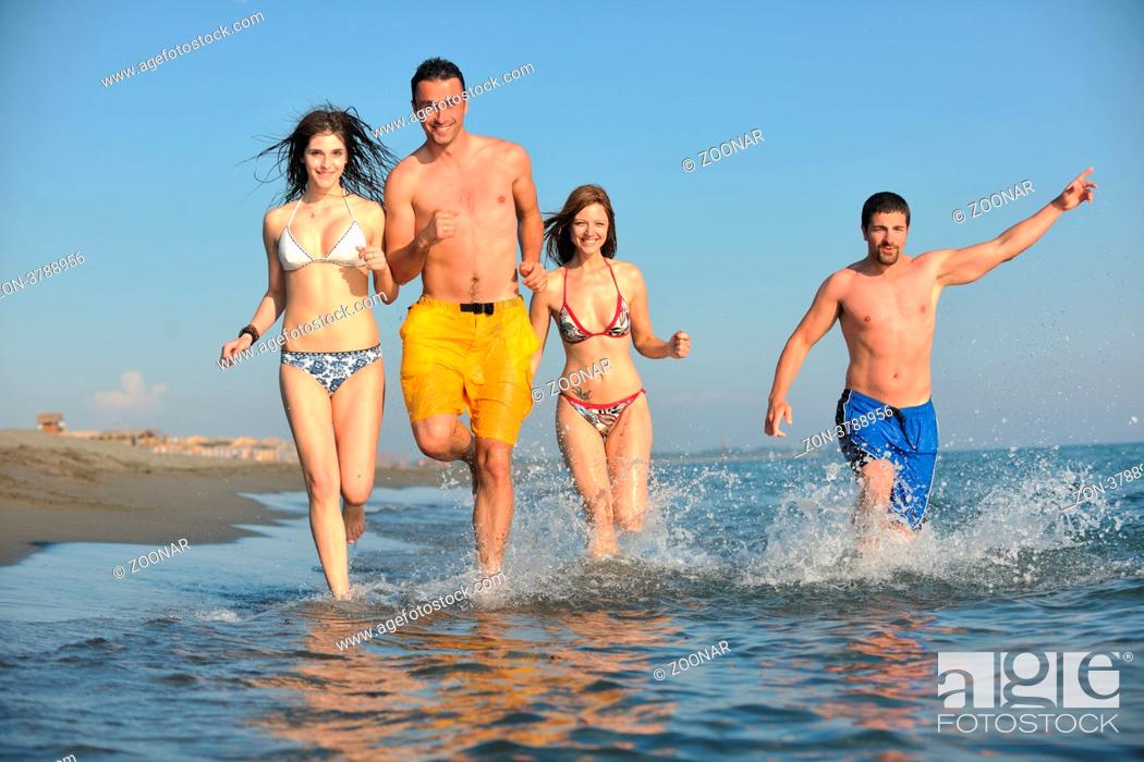 Stock Photo: happy people group have fun run and jump on beach beautiful sand beach.