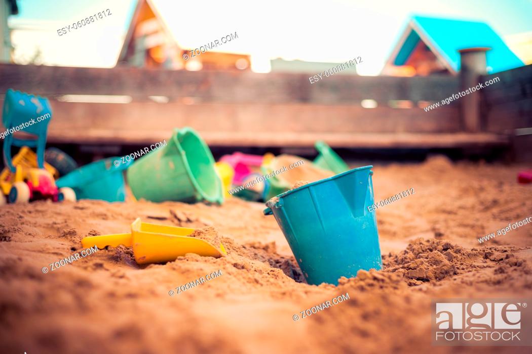 Stock Photo: Children plastic toys in the sand box. Dirt bucket, selective focus.