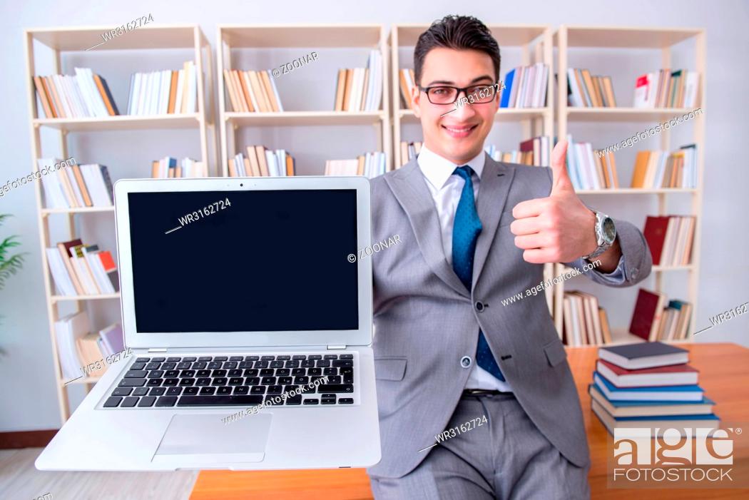 Stock Photo: Businessman with a blank screen laptop working in the library.