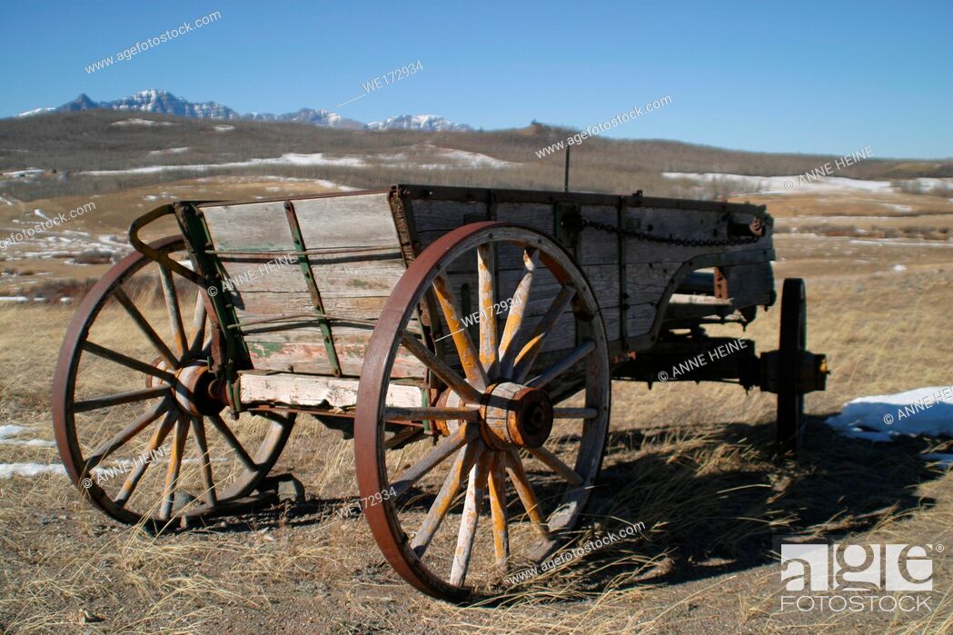 Stock Photo: Abandoned old horse-drawn carriages on farmland. Along Cowboy Trail (Hwy 22) near Longview. Rocky Mountains in background.