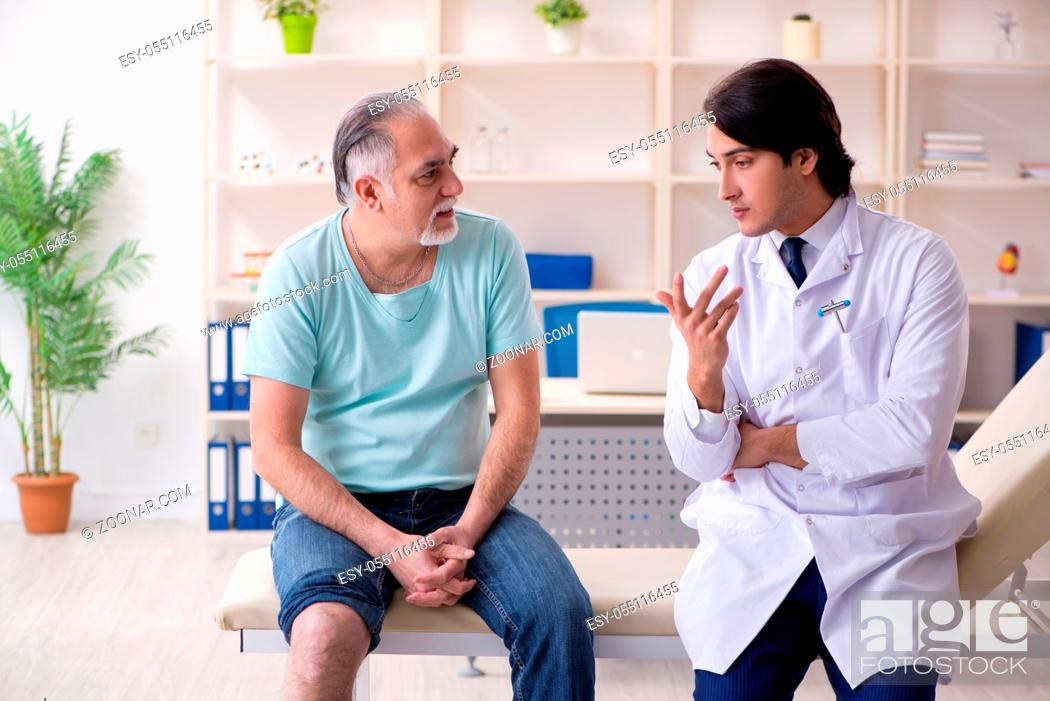 Stock Photo: Old man visiting young male doctor.