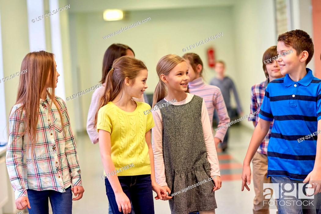 Stock Photo: education, elementary school, drinks, children and people concept - group of smiling school kids walking in corridor.