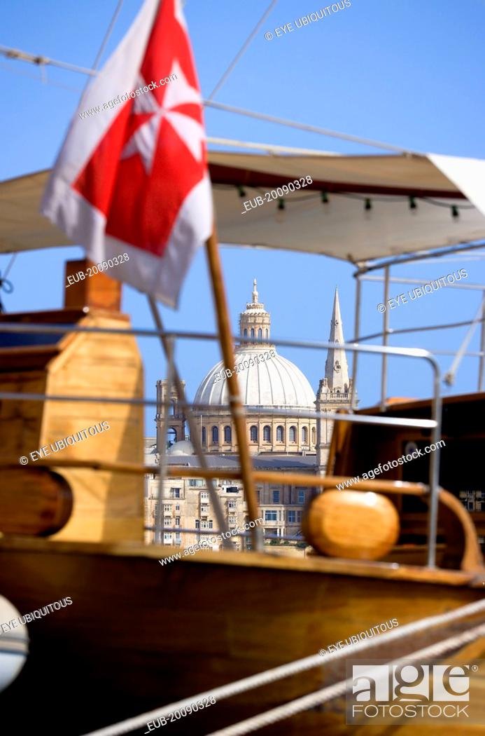 Stock Photo: The dome of the Carmelite Church of 1573 seen through the foredeck of an old schooner with a Maltese Cross flag moored on Sliema waterfront.