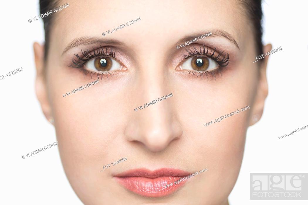 Imagen: Close-up portrait of confident mid adult woman against white background.