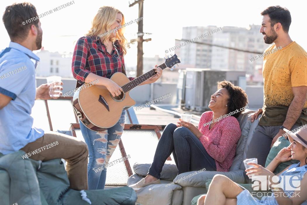 Stock Photo: Friends having a rooftop party and playing guitar.