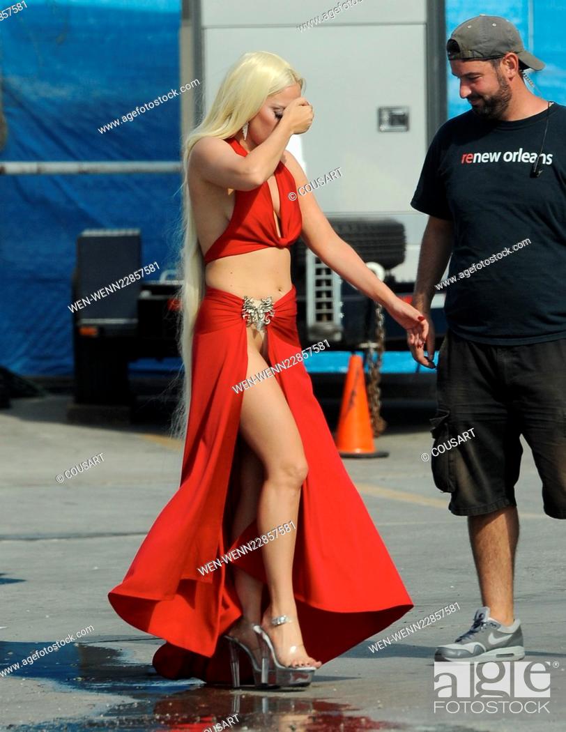 Stock Photo: Lady Gaga leaves little to the imagination as she steps out of her trailer in a red dress with a long slit that showed off her toned legs for a scene in.
