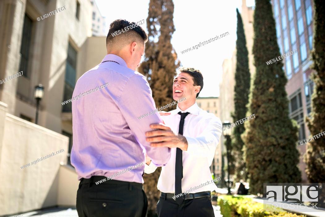 Stock Photo: Two businessmen shaking hands outdoors.