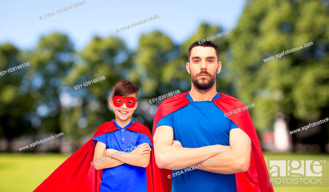 Stock Photo: family, power and people concept - man and boy wearing mask and red superhero cape over summer park background.
