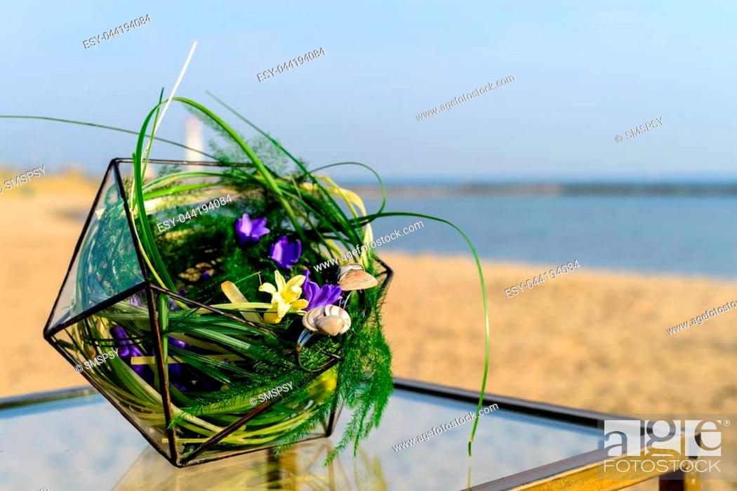 Stock Photo: Beautiful glass florarium glass with succulent plants on the table on the beach.