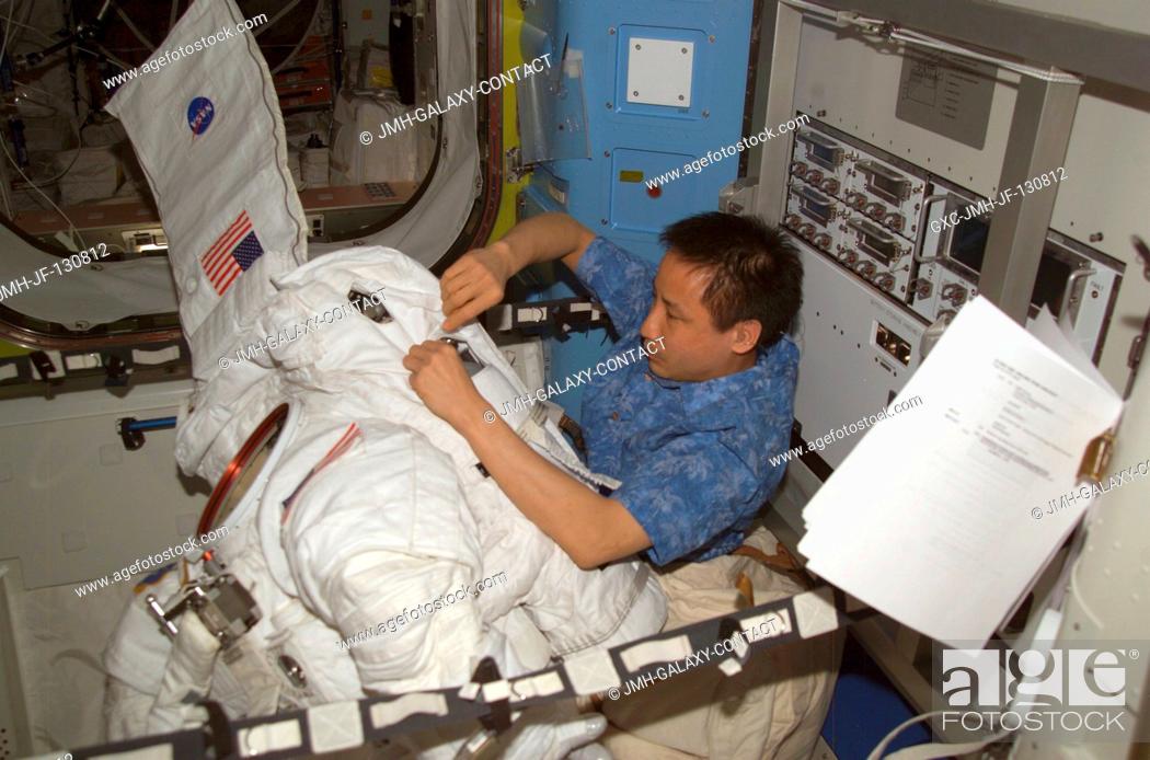 Stock Photo: Astronaut Edward T. Lu, Expedition 7 NASA ISS science officer and flight engineer, performs routine maintenance on an Extravehicular Mobility Unit (EMU) space.