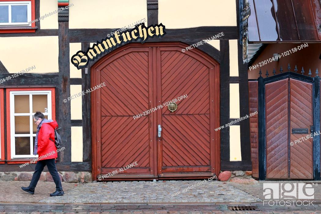 Stock Photo: 04 January 2023, Saxony-Anhalt, Salzwedel: The word Baumkuchen is written on an archway in the city center. The traditional company Salzwedeler Baumkuchen GmbH.