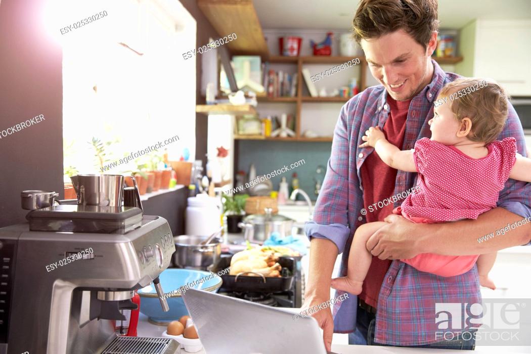 Stock Photo: Father With Young Daughter Using Laptop In Kitchen.