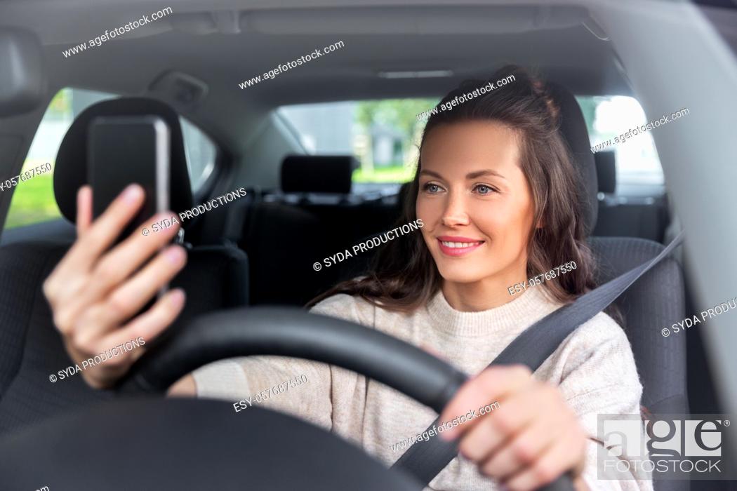 Stock Photo: woman or driver driving car and taking selfie.