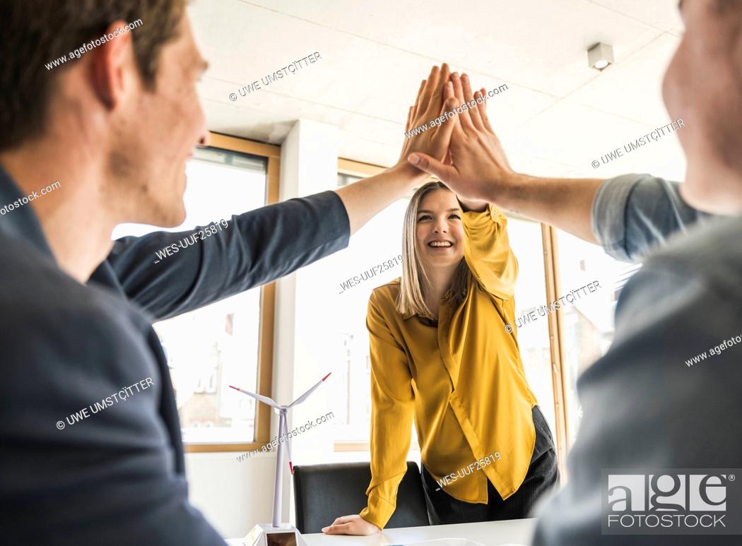 Photo de stock: Happy business team high fiving in office.