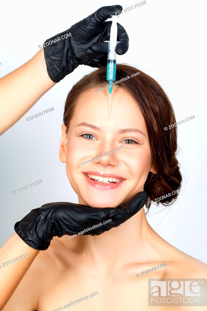 Stock Photo: beautiful young woman getting beauty injection. studio shot isolated on white background. copy space.