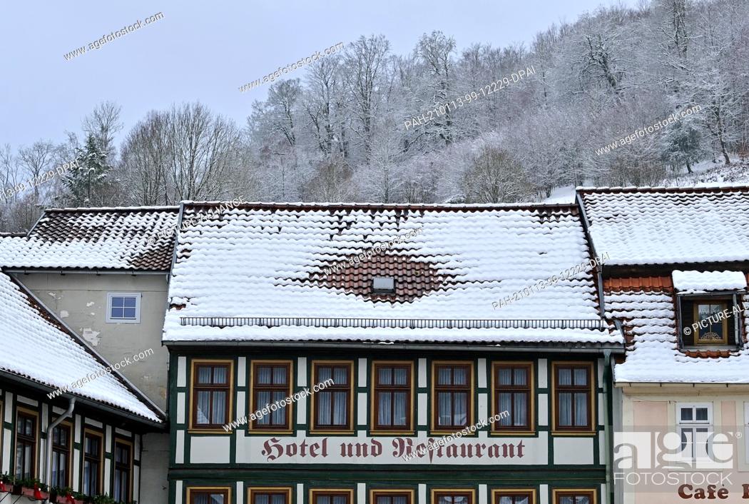 Stock Photo: 13 January 2021, Saxony-Anhalt, Stolberg: Snow lies on the roof of a hotel in the centre of Stolberg in the Harz Mountains.
