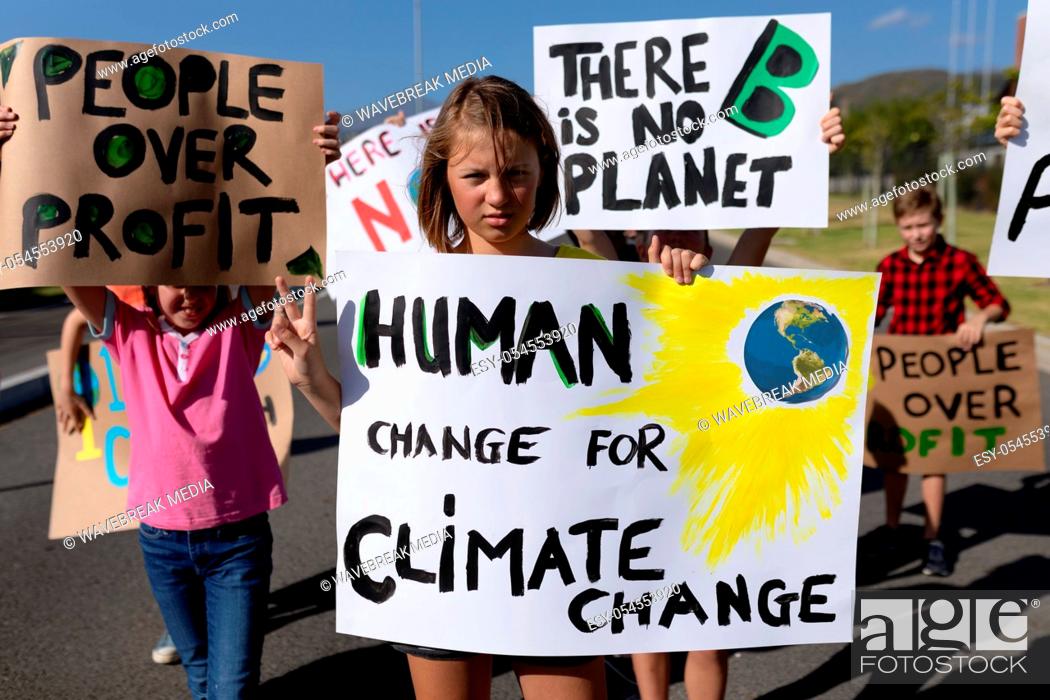 Stock Photo: Front view of a diverse group of elementary school pupils on a protest march, carrying signs with environmental and conservation slogans on them.