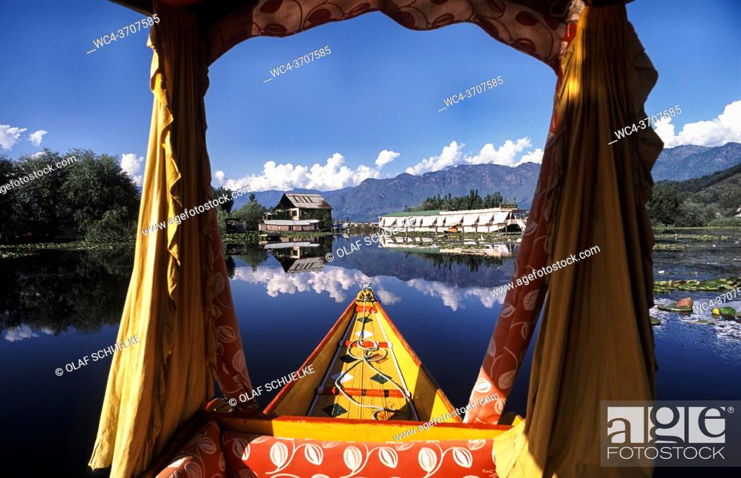 Stock Photo: Srinagar, Jammu and Kashmir, India, Asia - A traditional wooden Shikara boat with its typical drapes and baldachin crosses the Dal Lake while the surrounding.