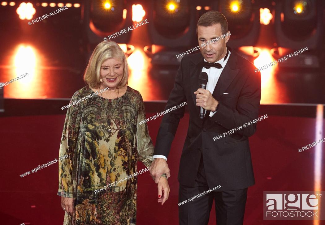 Stock Photo: 20 October 2021, Hamburg: Jutta Speidel, actress and laudator, and Kai Pflaume, presenter, stand on stage at the Neue Flora during the ""Golden Bild der Frau.