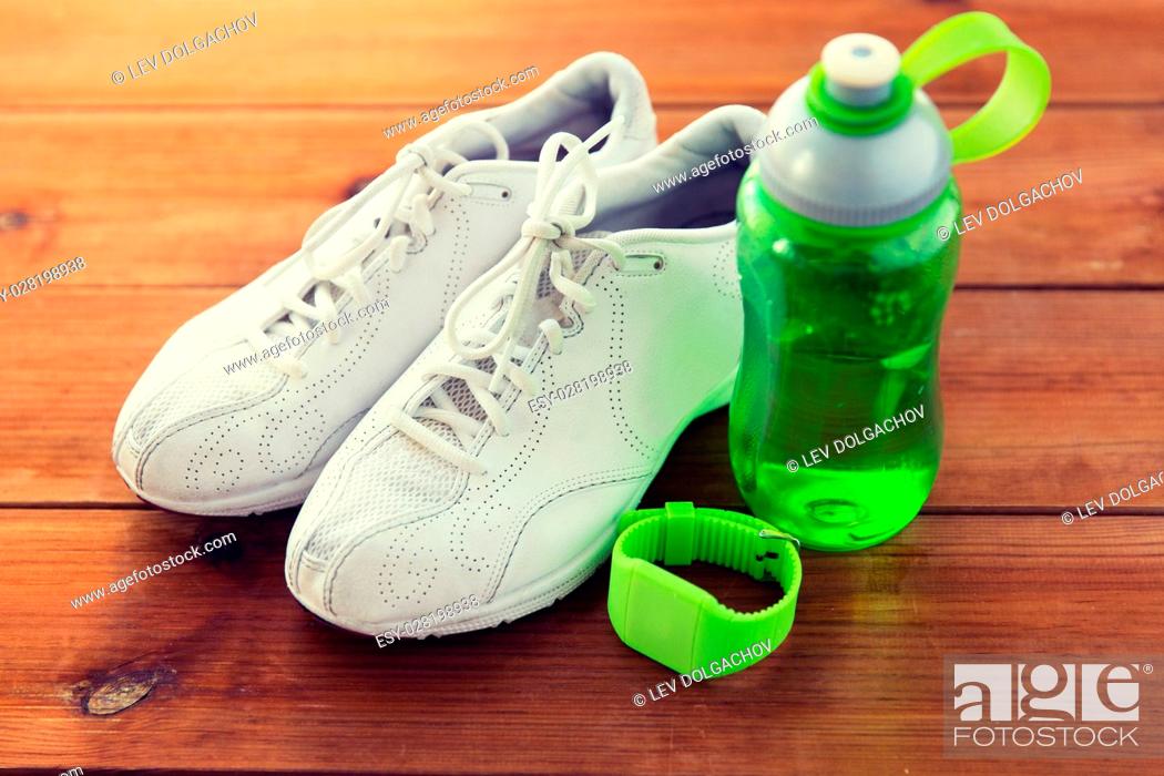 Stock Photo: sport, fitness, healthy lifestyle and objects concept - close up of sneakers, bracelet and water bottle on wooden floor.