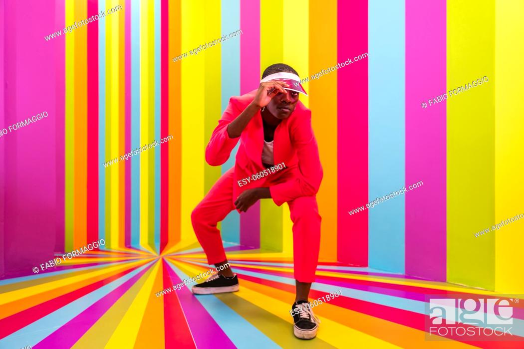 Stock Photo: Beautiful african american young woman dancer having fun inside a rainbow box room - Cool and stylish afro adult woman portrait on multicolored background.