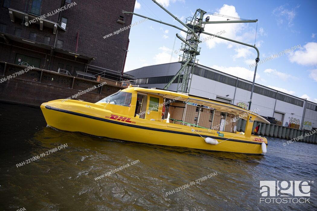 Stock Photo: 06 October 2022, Berlin: A Deutsche Post DHL solar ship sails into Berlin's Westhafen. DHL launches parcel transport by water with an electrically powered solar.