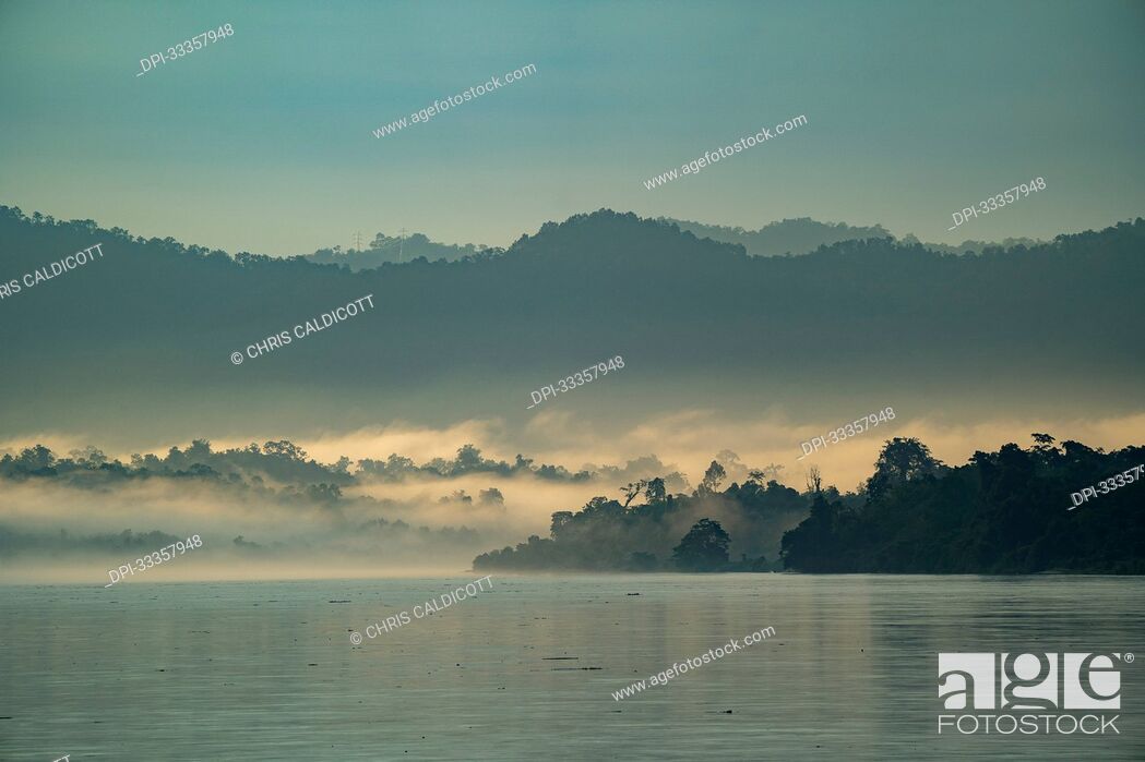 Stock Photo: Dawn, with sunlit morning mist rising over the jungle covered banks of the Ayeyarwady (Irrawaddy) River at dawn; Rural Jungle, Kachin, Myanmar (Burma).