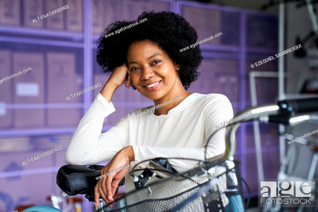 Photo de stock: Mid-shot portrait of African-American woman standing in her bicycle shop.