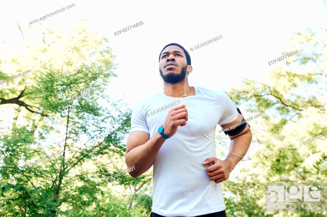 Imagen: Focused african american young sportsman running outdoors.