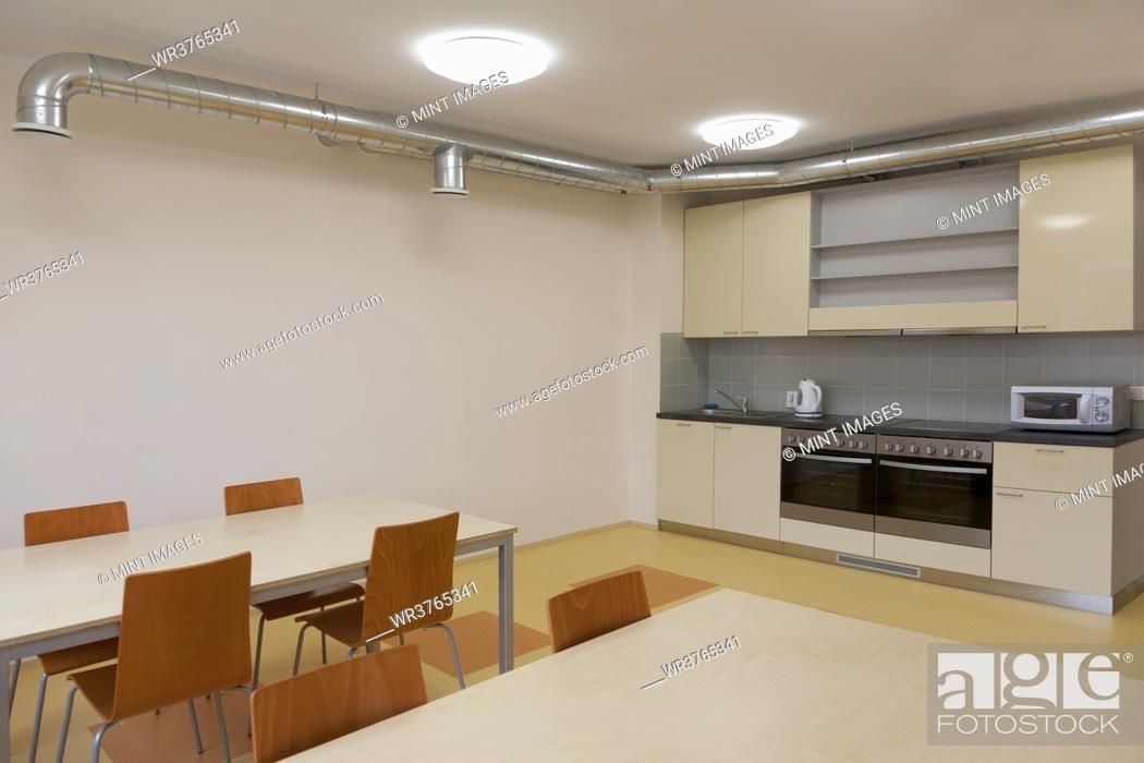 Stock Photo: Modern youth hostel building. Kitchen and eating areas. Two ovens, kettle and toaster.