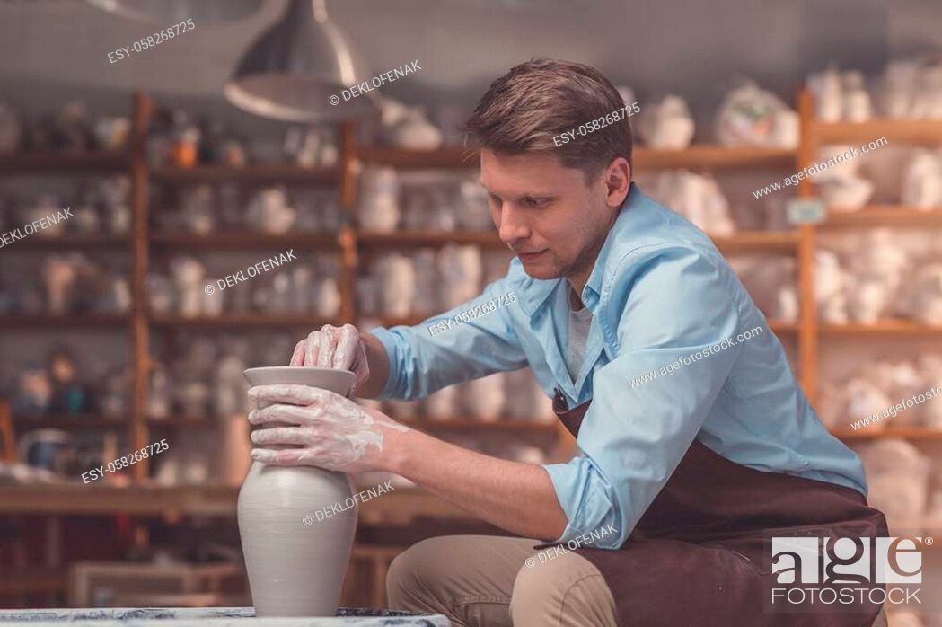 Stock Photo: Young man with a potter's wheel in pottery.