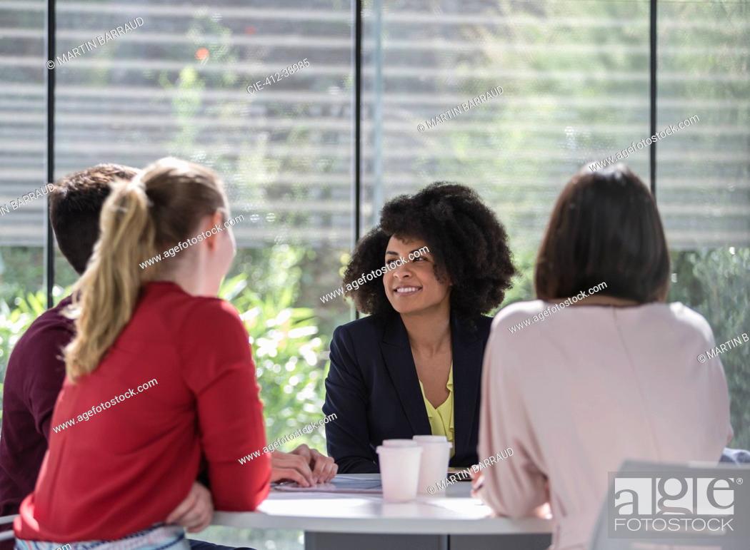 Stock Photo: Businesswomen talking, planning at table in meeting.