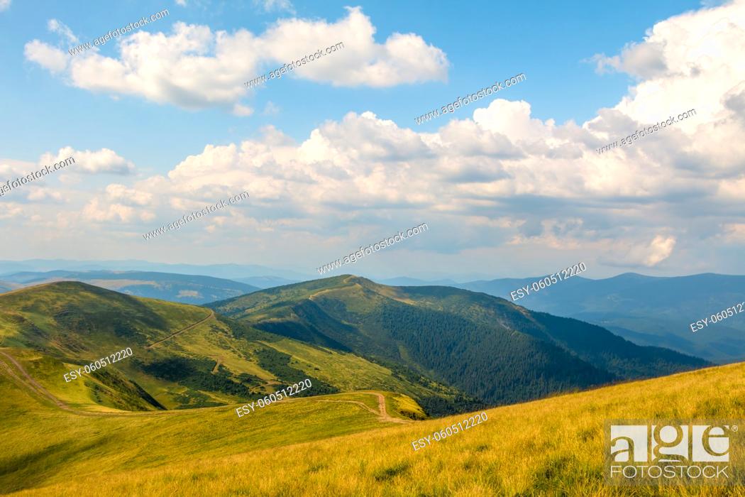 Stock Photo: Summer Carpathians. Beautiful clouds in the blue sky over the tops of the old mountains. High point shooting.