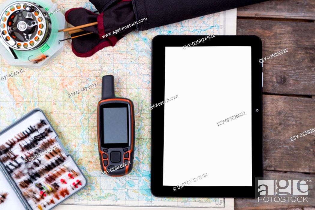 Stock Photo: mockup intend to fishing journey with fly-fishing tackles and gps navigator and pad on paper map background.