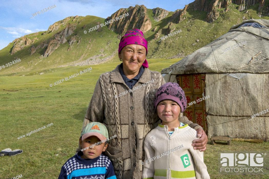 Stock Photo: Kirghizistan, Naryn province, grandmother with her grandchildren in their nomadic camp of yourtas.