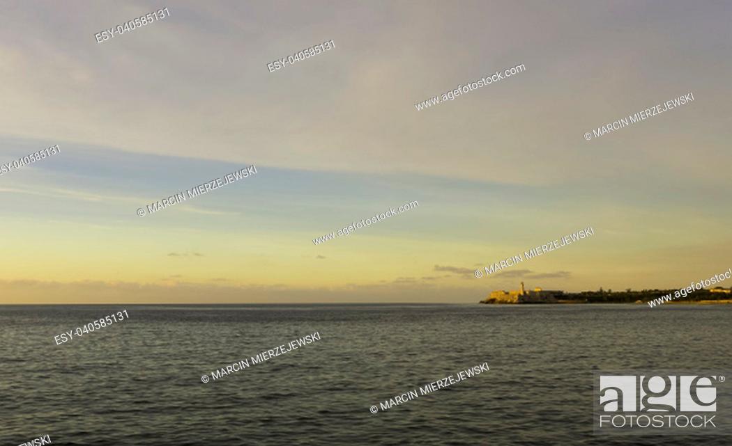 Stock Photo: Sunset over Malecon and Atlantic Ocean with Morro Castle in background - Havana, Cuba.