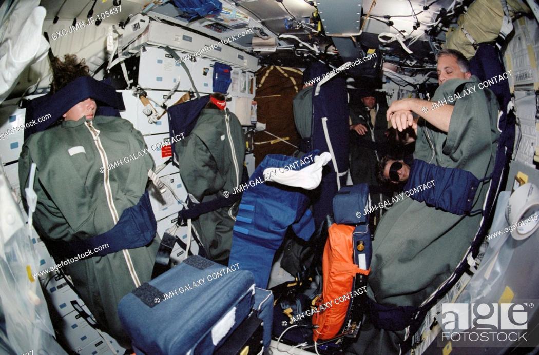 Stock Photo: The STS-112 crewmembers sleep on the middeck of the Space Shuttle Atlantis. Pictured are astronauts Sandra H. Magnus, David A. Wolf, Piers J.