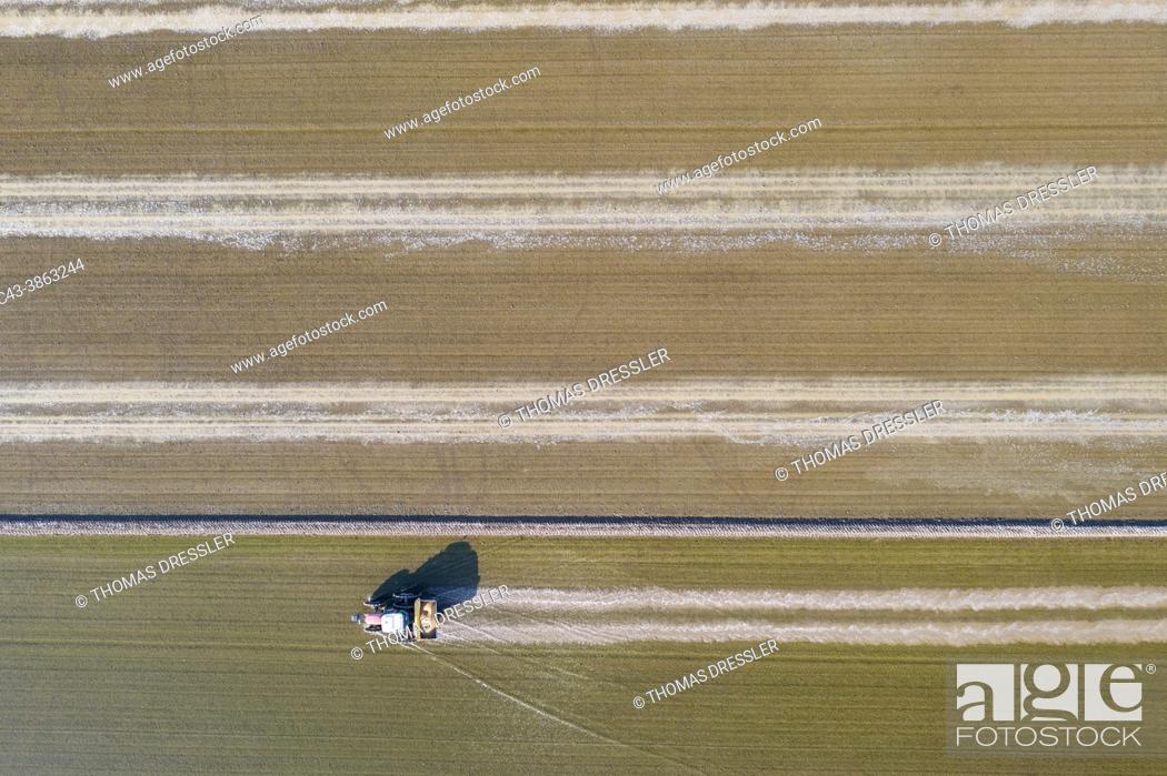 Stock Photo: Tractor sowing rice seeds in a flooded rice field in May. Aerial view. Drone shot. Ebro Delta Nature Reserve, Tarragona province, Catalonia, Spain.