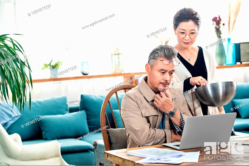 Photo de stock: Middle-aged couples using laptop at home.